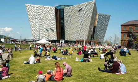 Belfast, Northern Ireland, UK. 30th May 2016. UK weather: Belfast basks in sunshine with a temperature of around 23C as the Maritime Festival continues. People relax and enjoy the sunshine on the grass area in front of the Titanic Building. Credit: J Orr/Alamy Live News